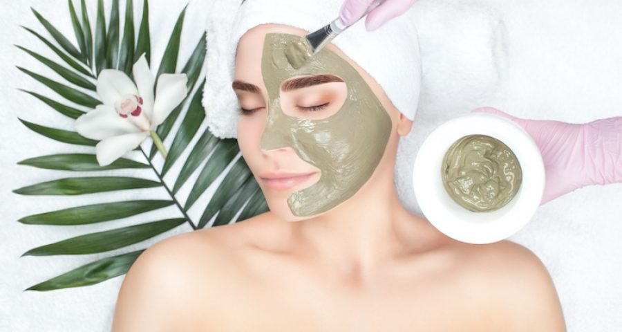 The procedure for applying a mask from clay to the face of a beautiful woman Gesichtsbehandlungen Esensa Mediterana